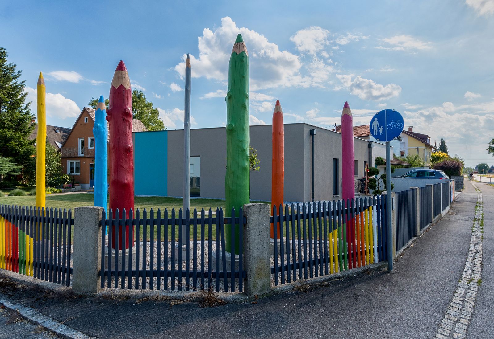 Neubau mit bunten Holzstiften am Zaun