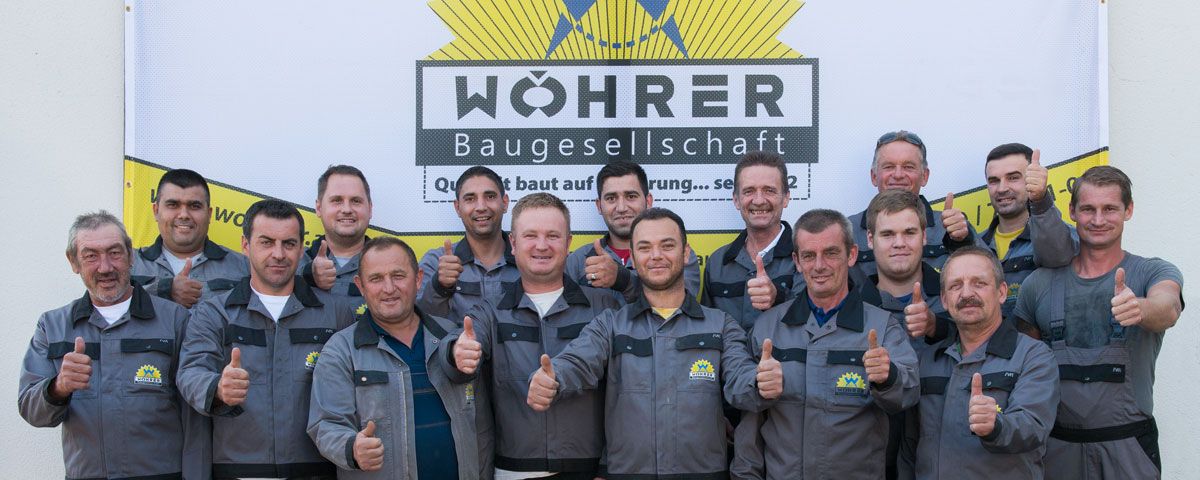 Das ganze Team der Wöhrer Baugesellschaft vor dem Firmenbanner